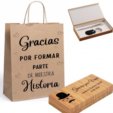 Stylo et porte-clés dans une boîte en bois personnalisée avec une phrase et des noms, présentés dans un sac kraft avec une