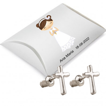 Boucles d'oreilles en forme de croix présentées dans une boîte en carton argenté et un autocollant de communion avec un nom