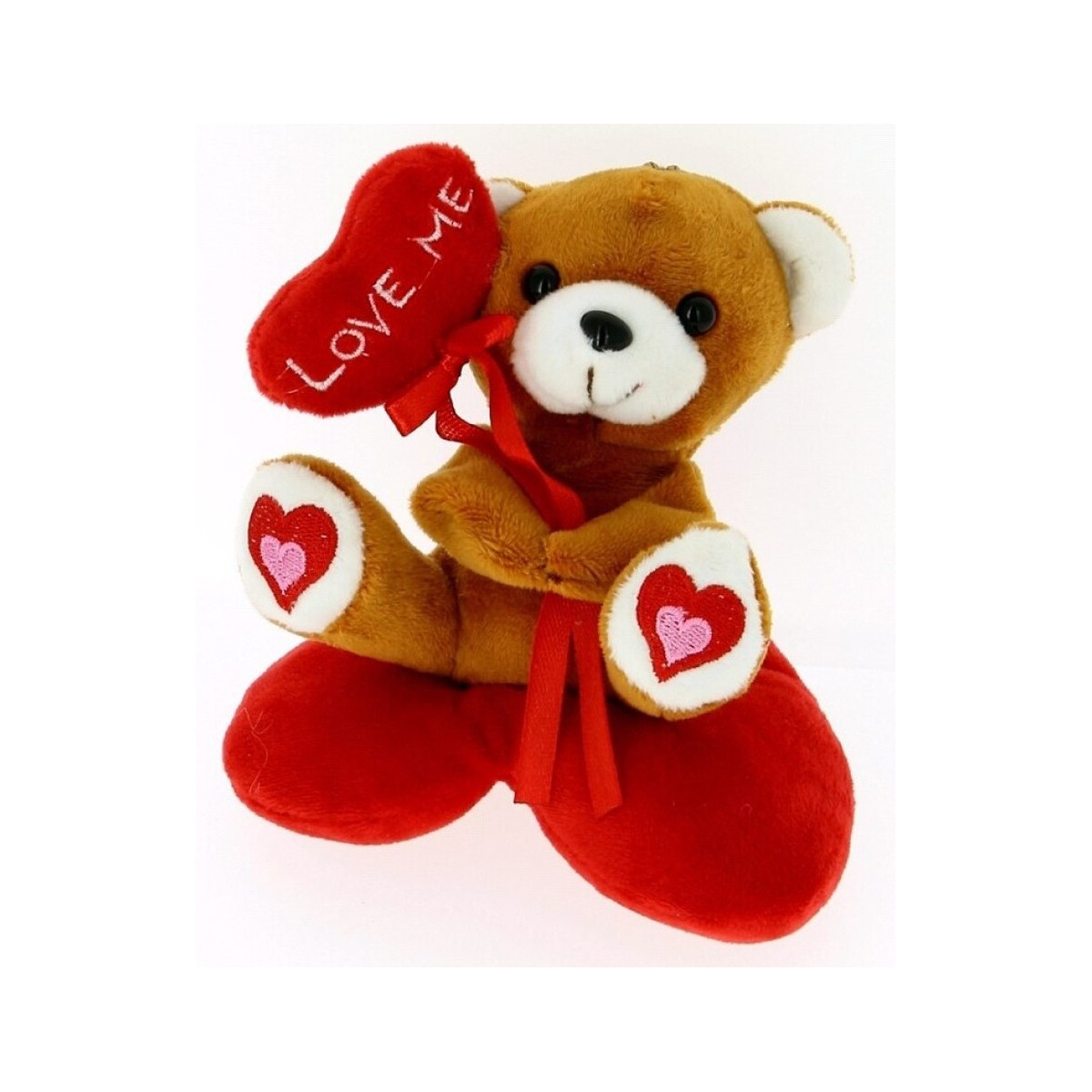 Ours en peluche sur coussin en forme de coeur