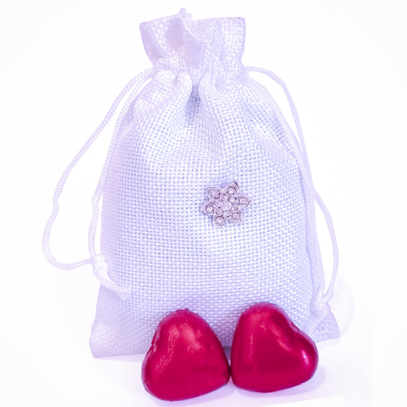 épingle de mariée avec décoration sur un sac blanc et chocolats en forme de coeur