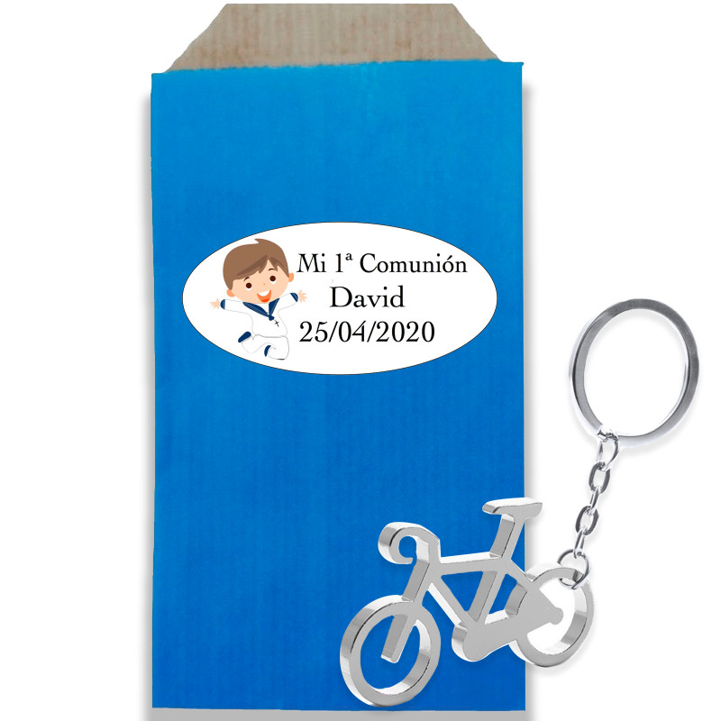 Porte-clé en forme de vélo en argent dans une enveloppe kraft avec un autocollant personnalisé pour la communion d'un garçon
