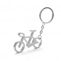 Porte-clé en forme de vélo en argent dans une enveloppe kraft avec un autocollant personnalisé pour la communion d'un garçon