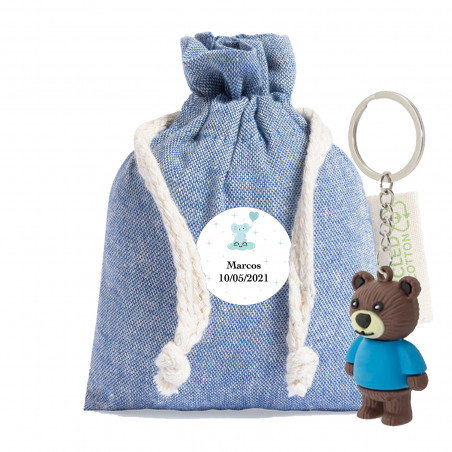 Porte-clé en forme d'ours présenté dans un sachet en tissu avec un autocollant personnalisable de baptême