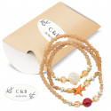 Bracelet à breloques marin dans une enveloppe kraft avec autocollant initial pour plus de détails