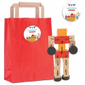 Jeu de compétence en bois transformer dans un sac kraft rouge et autocollant pour anniversaire