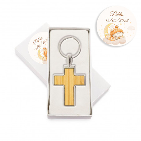 Porte-clés en forme de croix en métal avec bambou dans une boîte personnalisée avec un autocollant de baptême pour un détail.