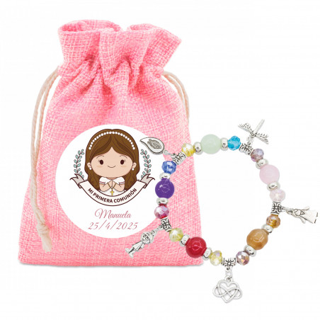 Bracelet avec des perles colorées et des charms dans un sac en tissu rose et un autocollant spécial pour la communion fille