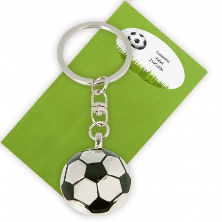 Porte-clés en forme de ballon de football présenté dans une enveloppe verte et adhésif avec texte
