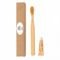 Brosse à dents en bambou et pâte dentifrice dans une boîte avec un autocollant pour les détails des événements et des fêtes.