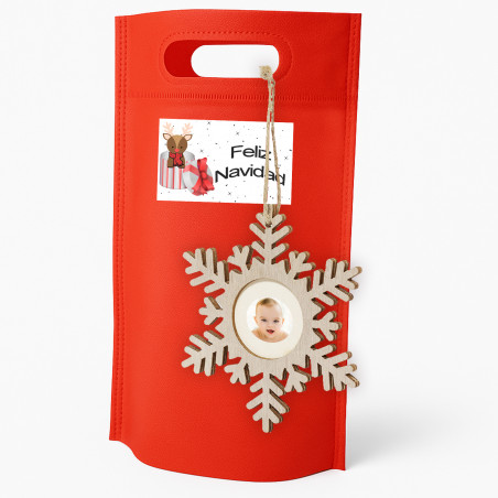 Suspension de Noël avec photo en forme de flocon de neige présentée dans un sac cadeau rouge et autocollant personnalisé